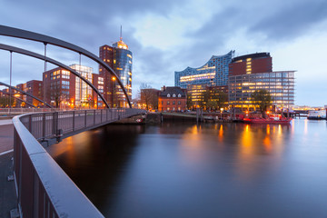 Fototapeta premium Speicherstadt during twilight in Hamburg, Germany, reflection of lights and buildings on water in canal