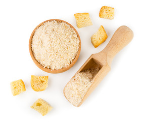 Pieces of dried bread and breadcrumbs in a wooden plate and spoon on a white. Isolated, top view.