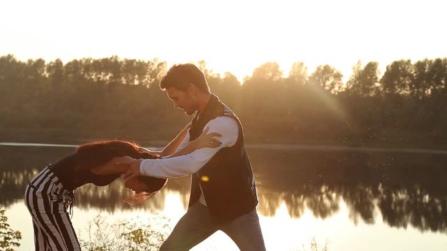 Concept of love and relationships. Young couple dancing at sunset