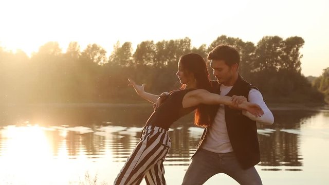 Concept of love and relationships. Young couple dancing at sunset