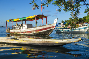 Brazilian boats reflecting in tranquil waters on a remote coast in Bahia Nordeste Brazil