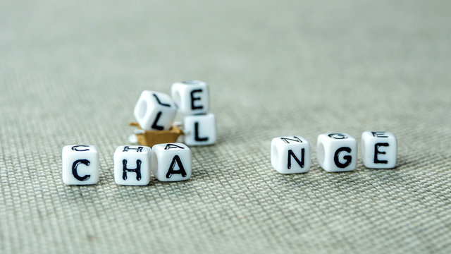 Removing white cubes with letters l and e of the word challenge creating new word change on grey background with miniature figurines