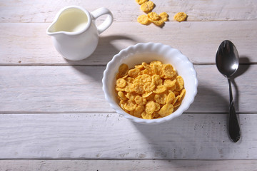 Corn Flakes cereal in a bowl and glass with milk. Morning breakfast.