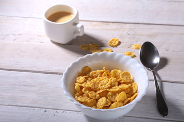 Corn Flakes cereal in a bowl and cap with espresso coffee. Morning breakfast.