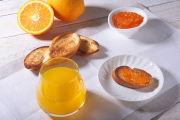 Naklejka na ściany i meble Morning Breakfast set with orange jam on bread toast and juice in glass.