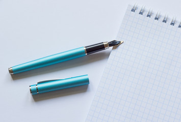 Fountain pen and notebook on a white background