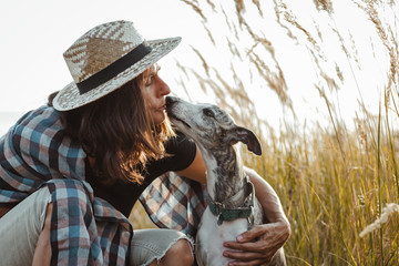 Pet owner woman kissing her cute dog