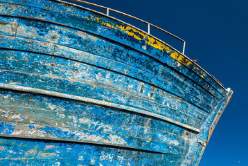 The hull of an old fishing boat in dry dock on a dock at the port of Essaouira in Morocco