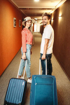 Smiling Couple With Suitcase In Hotel Hallway