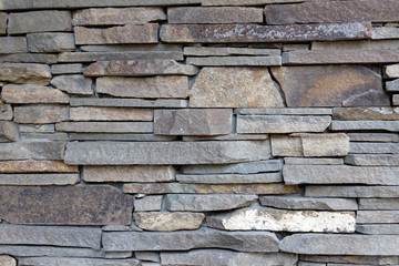 Decorative wall of artificial torn stone. Stone masonry as background or texture.