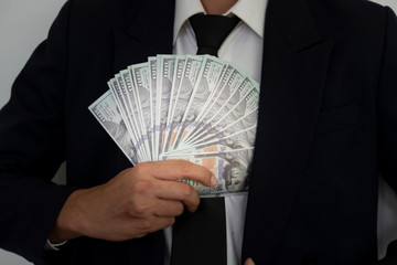 Business Man Displaying a Spread of dollars.