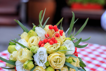 Wedding bouquet and wedding rings. The concept of celebrating, tradition, love, decor.
