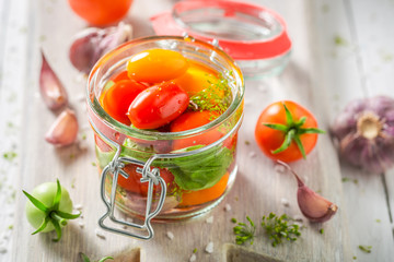 Homemade and tasty pickled red tomatoes in the jar