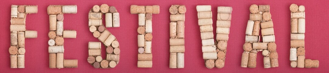 Word FESTIVAL made of wine corks on red Bordeaux background. Burgundy color and wine berry