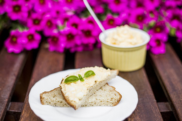 Yellow delicious egg and mayonnaise paste on whole what bread, breakfast snack recipe, pink flowers on the background, wooden base.