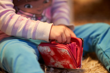 3 yearls old caucasian girl child is playing with money and wallet