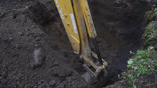 Excavator shovel digs into a ground