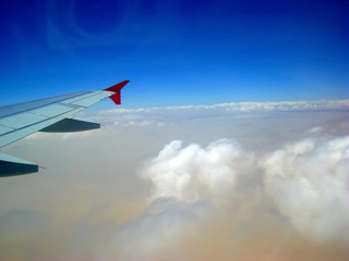 Beautiful blue sky with wonderful white clouds shown from airplane window