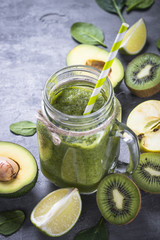 Healthy green smoothie in mason jar and ingredients. 