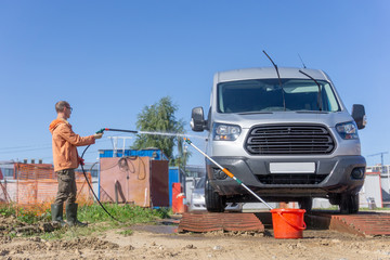 The driver is washing his minibus