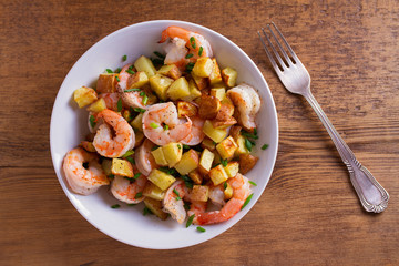 Shrimps with scallions and crispy potatoes. View from above, top studio shot