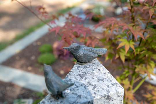 Zwei V&ouml;gel auf einem Grabstein 