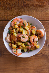 Shrimps with scallions and crispy potatoes. View from above, top studio shot