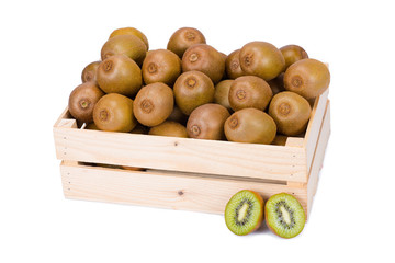 Wooden box filled with many ripe and fresh kiwi fruits and two half fruits in front of it isolated on white background