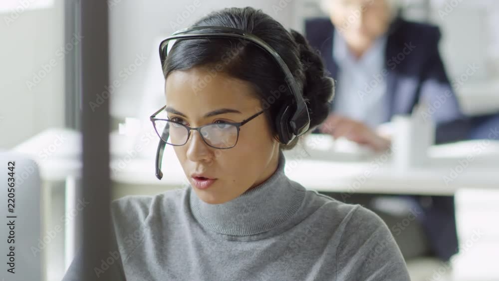 Poster medium shot of attractive young mixed race woman in glasses helping customer using desktop computer 