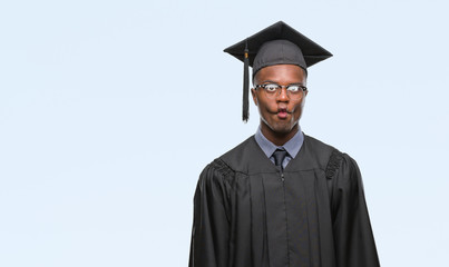 Young graduated african american man over isolated background making fish face with lips, crazy and comical gesture. Funny expression.