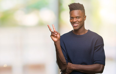 Young african american man over isolated background smiling with happy face winking at the camera doing victory sign. Number two.