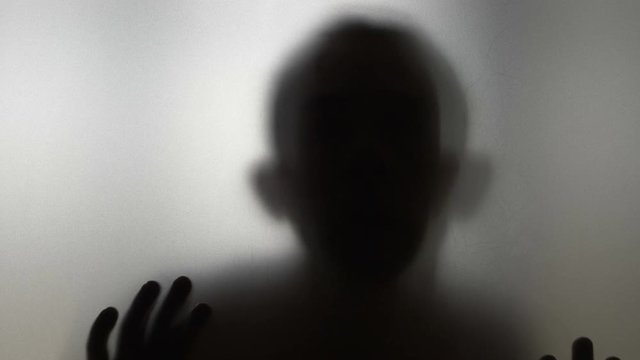 Peeper man looking from behind frosted glass in 4k slow motion 60fps