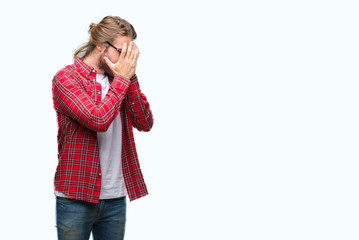 Young handsome man with long hair wearing glasses over isolated background with sad expression covering face with hands while crying. Depression concept.