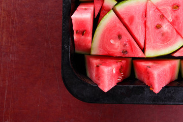 Watermelon slices. Pieces of ripe watermelon in old metal dishes. Red fruit with fructose for a...