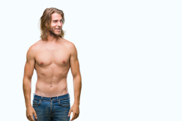 Fototapeta premium Young handsome shirtless man with long hair showing sexy body over isolated background looking away to side with smile on face, natural expression. Laughing confident.