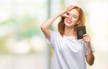 Young beautiful woman holding passport of canada over isolated background with happy face smiling doing ok sign with hand on eye looking through fingers