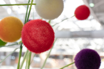 Colorful decorative fuzzy balls of red, white, yellow, purple colors.
