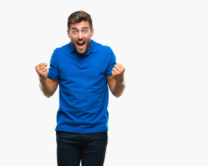 Fototapeta premium Young handsome man over isolated background celebrating surprised and amazed for success with arms raised and open eyes. Winner concept.