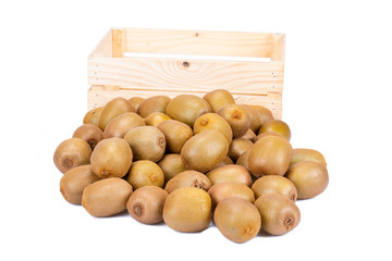 Empty wooden box and in the front of it a many fresh ripe whole kiwi fruits isolated on white background
