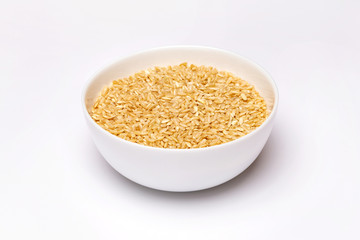 Closeup bowl of brown raw rice isolated at white background.