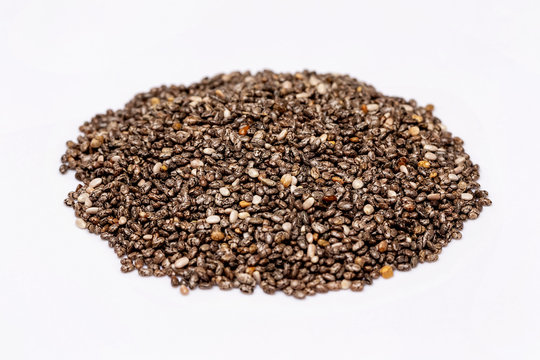 Macro image of chia superfood seeds pile isolated at white background.