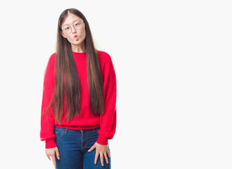 Obraz premium Young Chinese woman over isolated background wearing glasses making fish face with lips, crazy and comical gesture. Funny expression.