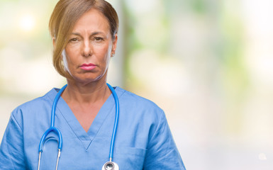 Middle age senior nurse doctor woman over isolated background depressed and worry for distress,...