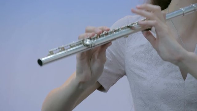 Symphony concert - unrecognizable woman playing flute - close up shot. Music and culture concept