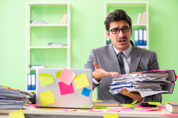 Businessman unhappy with many conflicting priorities sitting in 