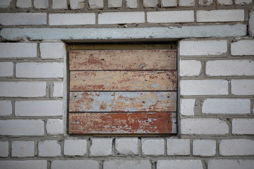 boarded-up window on a brick wall