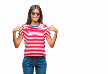 Obraz premium Young asian woman wearing sunglasses over isolated background looking confident with smile on face, pointing oneself with fingers proud and happy.
