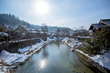 Miyagawa river and vintage buildings view looking from the other side of famous red bridge in Takayama called Nakabashi. view of local Japanese style house near Nakabashi bridge along side 