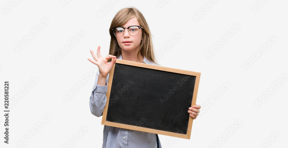 Sticker young blonde child holding blackboard doing ok sign with fingers, excellent symbol