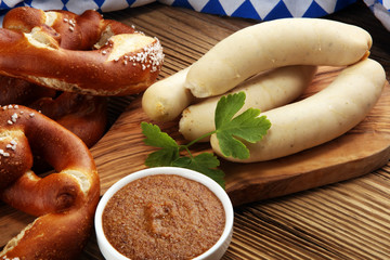 Bavarian veal sausage breakfast with sausages, soft pretzel and mild mustard on wooden board from...